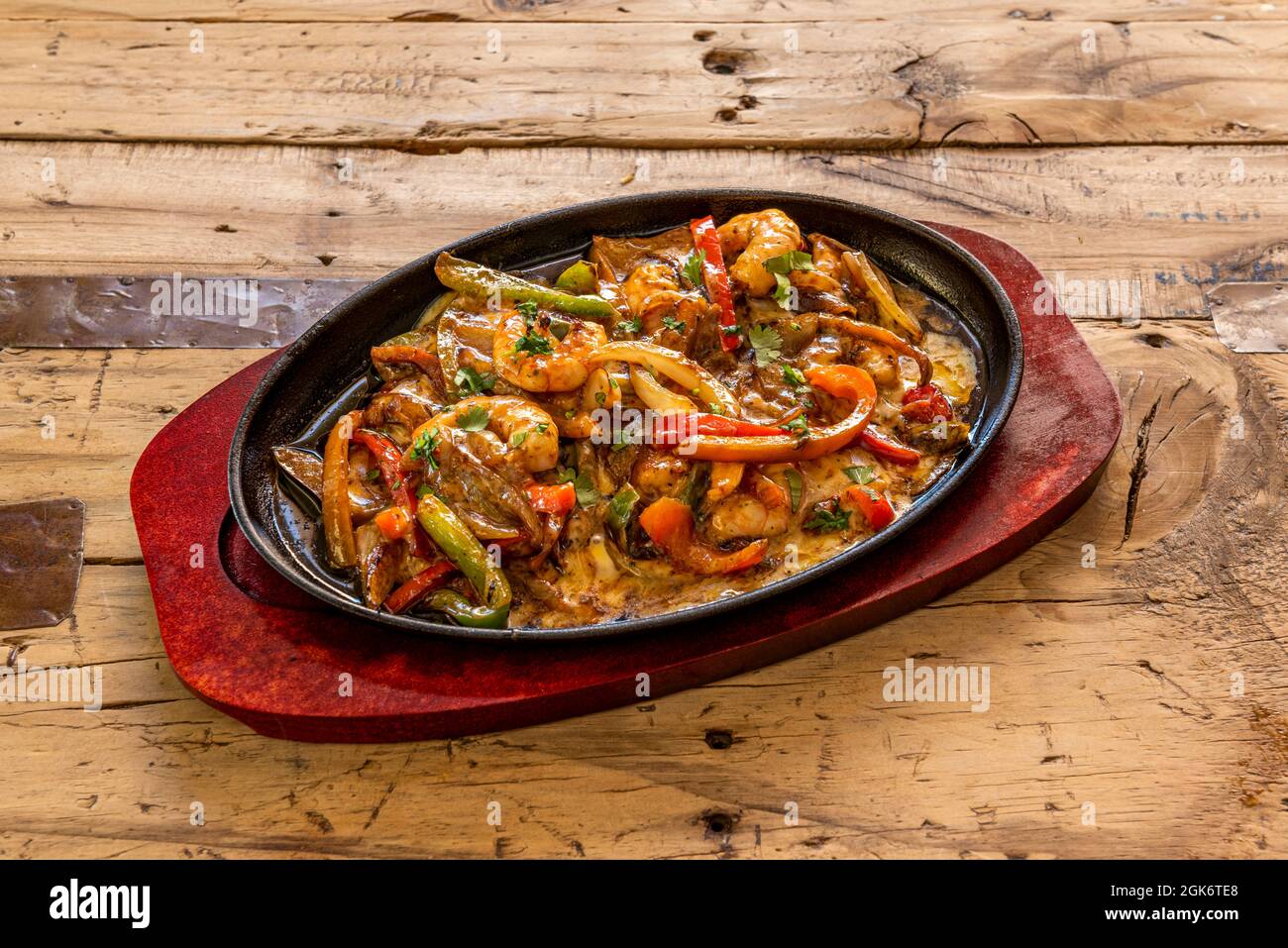 Plateau de recettes mexicain très populaire avec crevettes. Légumes sautés avec du fromage et des crevettes servis dans un récipient en fonte Banque D'Images