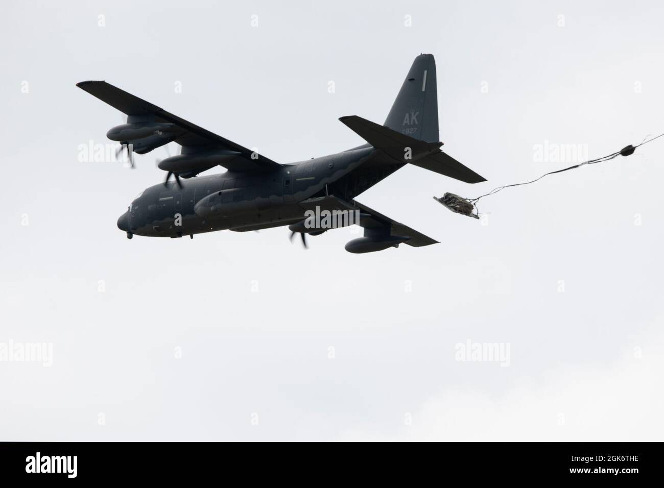 Un roi de combat HC-130J de la Garde nationale aérienne de l'Alaska exploité par l'équipage du 211e Escadron de sauvetage, 176e Escadre, dépose une palette d'équipement lourd au-dessus de la zone de chute de Malemute à la base conjointe Elmendorf-Richardson (Alaska), le 18 août 2021. Le HC-130J combat King II est une version spécialement modifiée et améliorée du très connu C-130 Hercules. Il peut effectuer des opérations de récupération du personnel, des opérations de recherche et de sauvetage, ainsi que des missions de ravitaillement en vol par hélicoptère aérien et de ravitaillement au sol. Banque D'Images