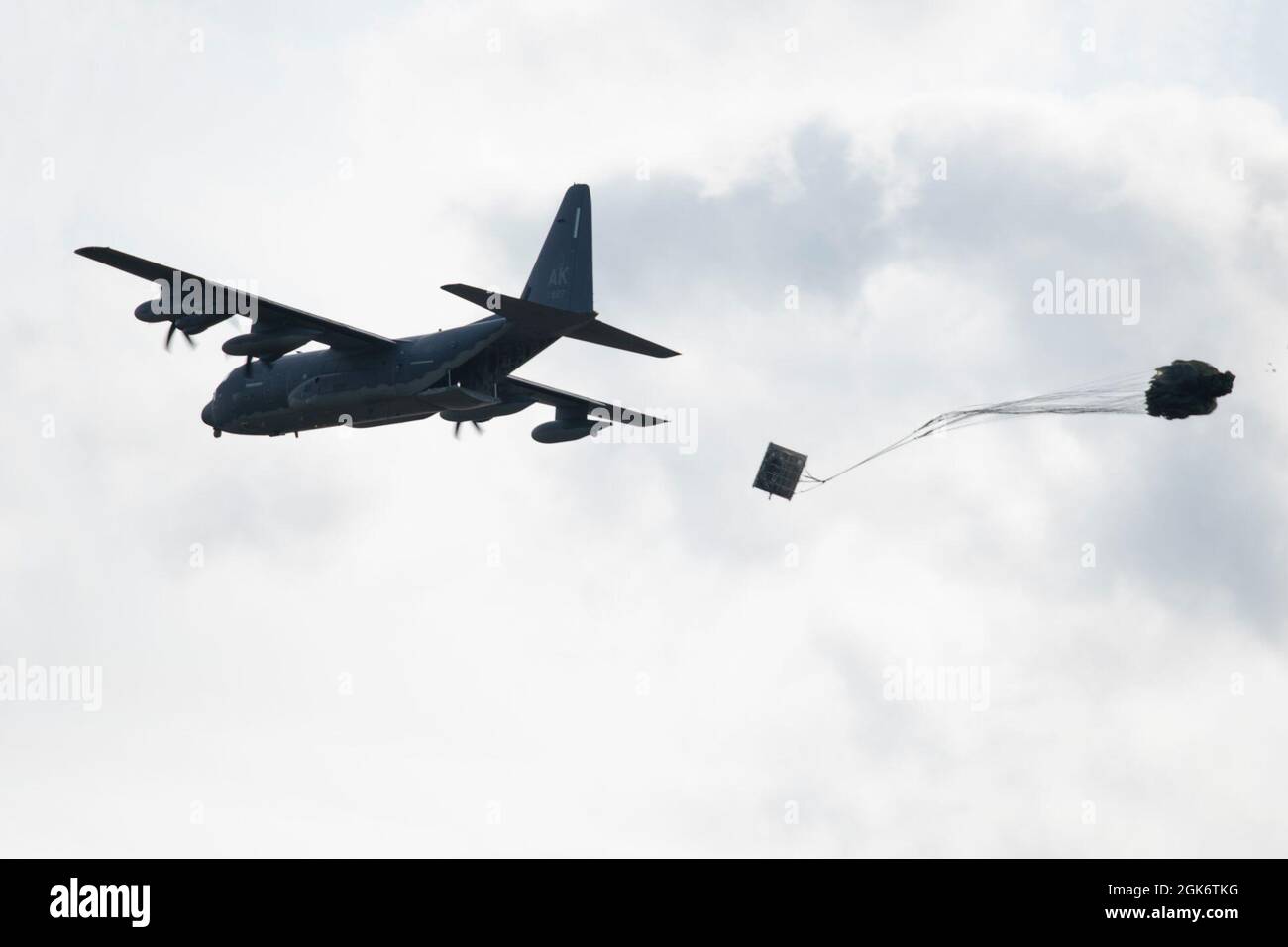 Un roi de combat HC-130J de la Garde nationale aérienne de l'Alaska exploité par l'équipage du 211e Escadron de sauvetage, 176e Escadre, dépose une palette d'équipement lourd au-dessus de la zone de chute de Malemute à la base conjointe Elmendorf-Richardson (Alaska), le 18 août 2021. Le HC-130J combat King II est une version spécialement modifiée et améliorée du très connu C-130 Hercules. Il peut effectuer des opérations de récupération du personnel, des opérations de recherche et de sauvetage, ainsi que des missions de ravitaillement en vol par hélicoptère aérien et de ravitaillement au sol. Banque D'Images