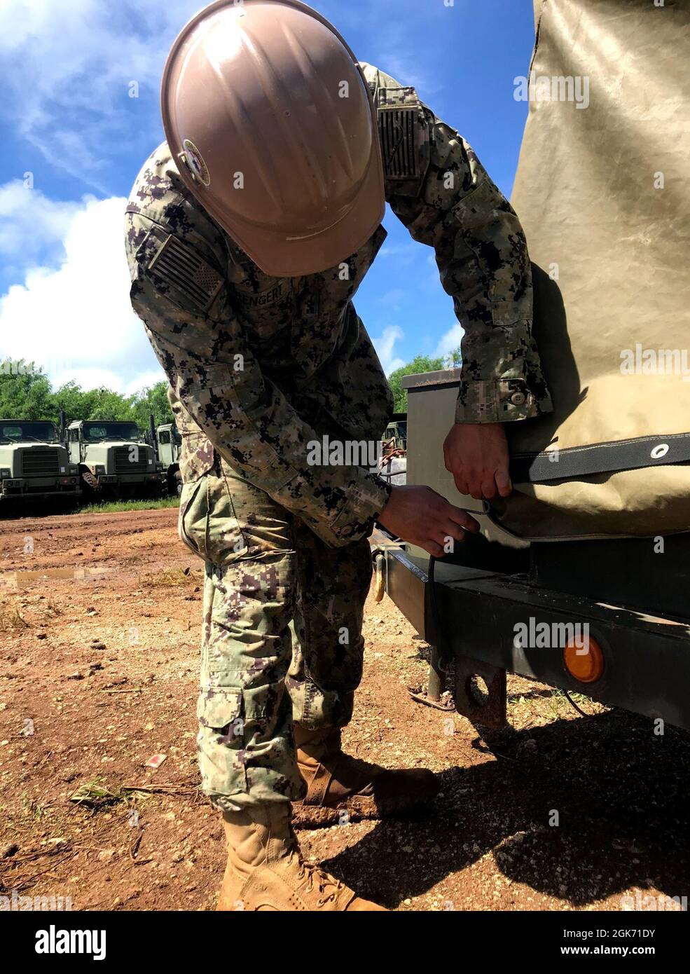 210819-N-OU239-1001 TINIAN, Îles Mariannes du Nord (août 19, 2021) le Constructionman Benjamin Rengert, affecté au détail Tinian du Bataillon de construction mobile navale (NMCB) 5, resserre une couverture protectrice sur une remorque de scie radiale pour se préparer aux conditions de préparation du cyclone tropical. Les Seabees de la Marine américaine affectés au NMCB-5 sont déployés dans la zone d'opérations de la 7e flotte des États-Unis, appuyant une Indo-Pacific libre et ouverte, renforçant notre réseau d'alliés et de partenaires, et fournissant un soutien général en génie et en civil aux forces opérationnelles conjointes. Abritel de Port Hu Banque D'Images