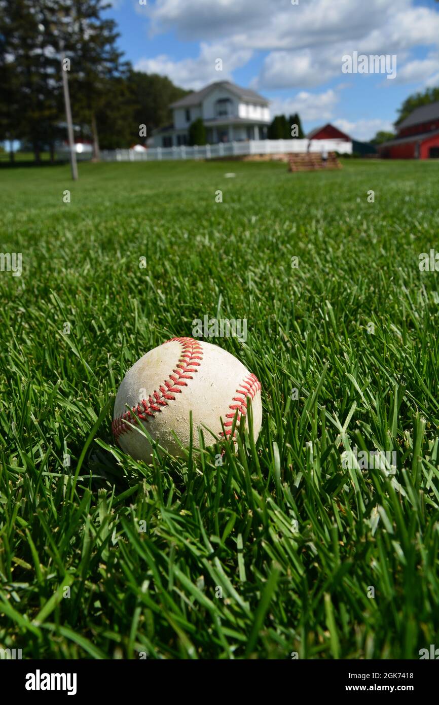 Un baseball se trouve dans l'herbe de l'outfield à l'ancien ensemble de films de The Field of Dreams à Dyersville Iowa. L'accent est mis sur le baseball. Banque D'Images