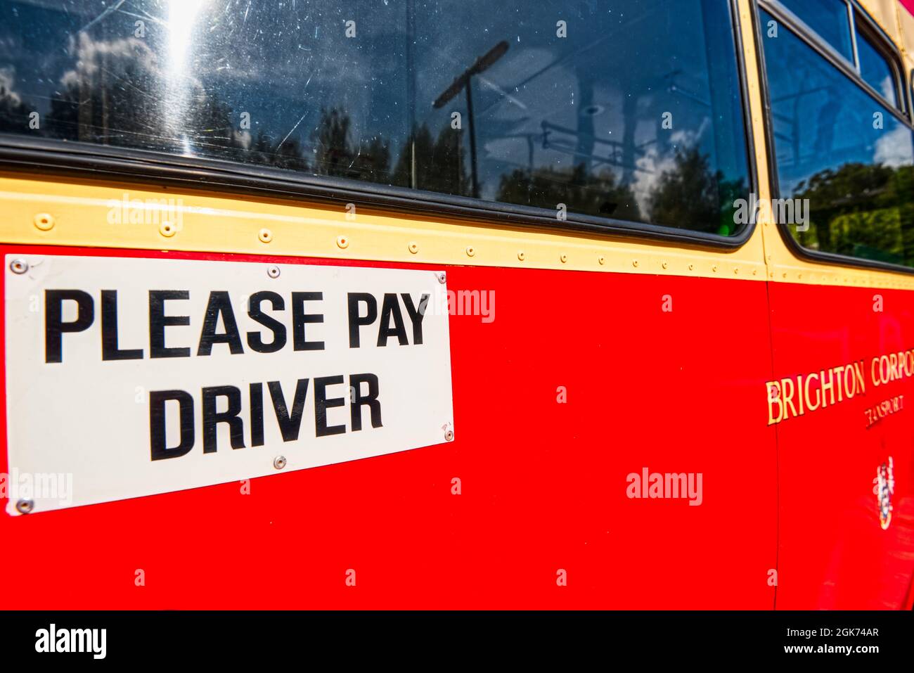 Veuillez payer le panneau du chauffeur sur le côté d'un bus d'époque, Winchester, Royaume-Uni Banque D'Images