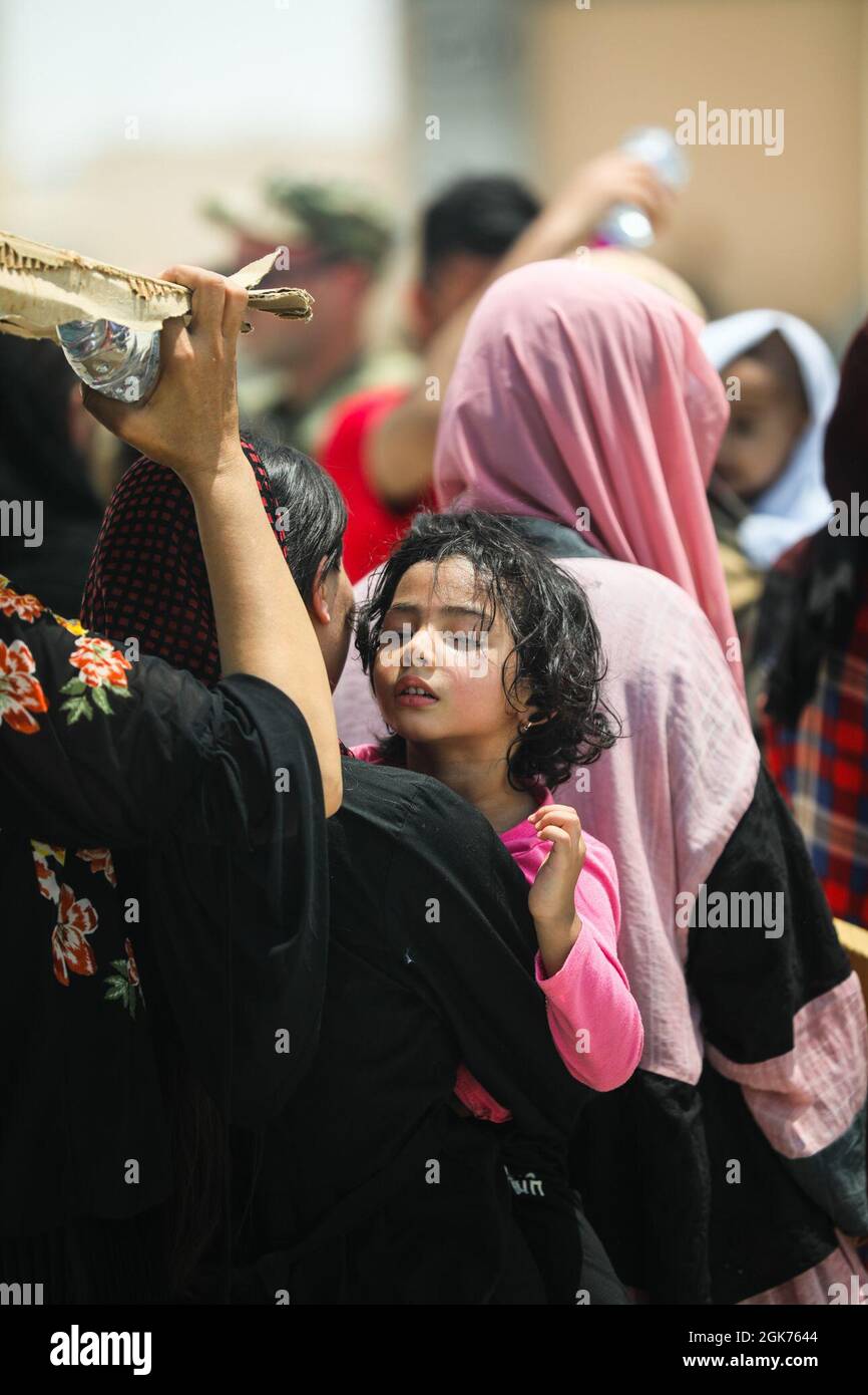 Un enfant afghan fatigué est transporté dans le restaurant de l'AOR du CENTCOM, le 21 août 2021. Dans le cadre de l'opération alliés refuge, les citoyens ont quitté l'aéroport international Hamid Karzaï de Kaboul, à bord de plusieurs avions militaires. Banque D'Images