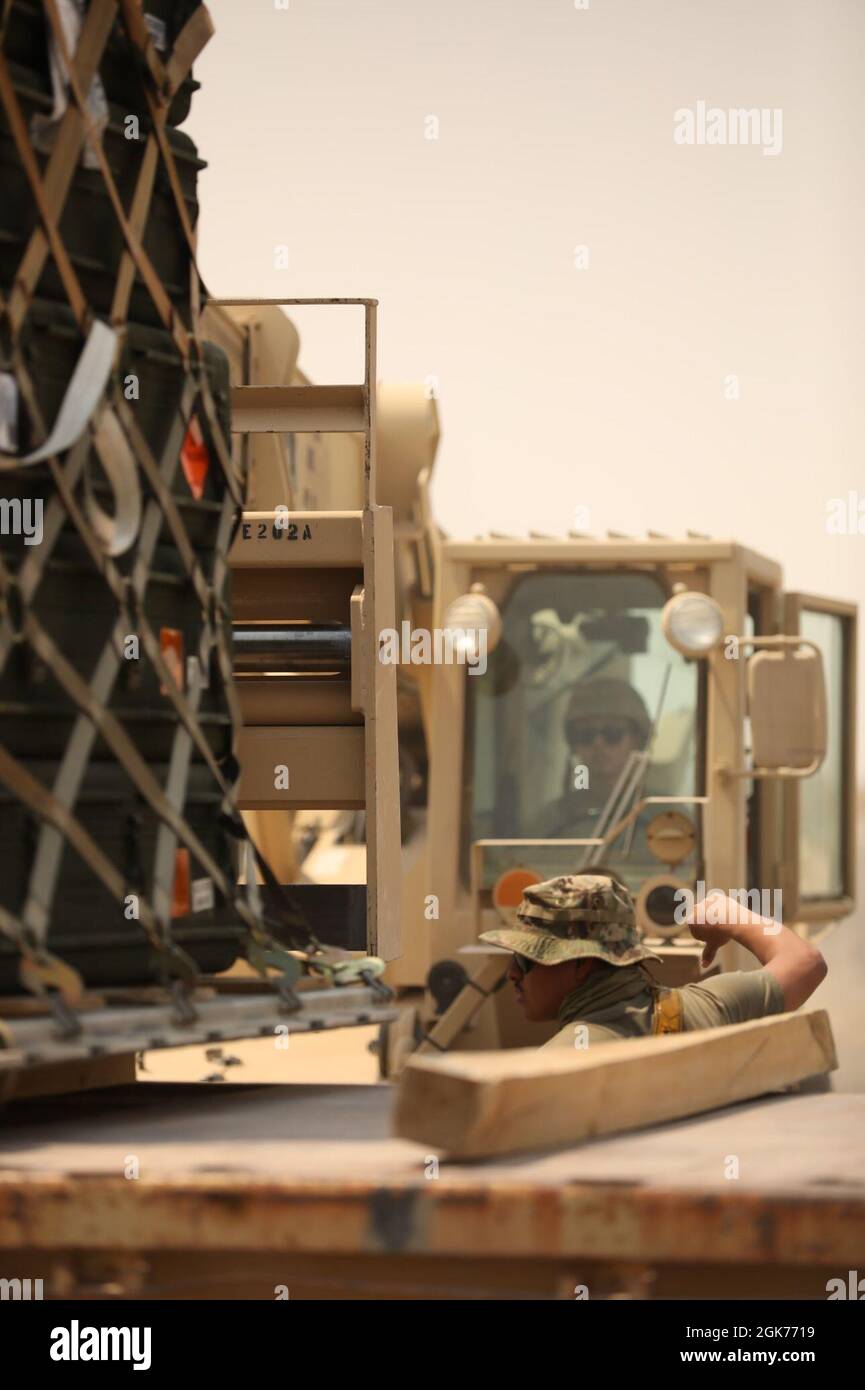 SPC. Christian Sanchez, spécialiste des munitions de la 163e Compagnie d’artillerie, du 311e Commandement du soutien expéditionnaire, du 393e Bataillon de soutien au combat, guides au sol comme soldat de l’armée américaine, se prépare à décharger les matériaux de classe V au chantier de munitions de la base aérienne Ali Al Salem, au Koweït, le 21 août 2021. Les matériaux de classe V ont été livrés à l'installation de munitions en transit pour fournir un soutien de munitions au centre de l'Armée des États-Unis et au Commandement central des États-Unis. Banque D'Images
