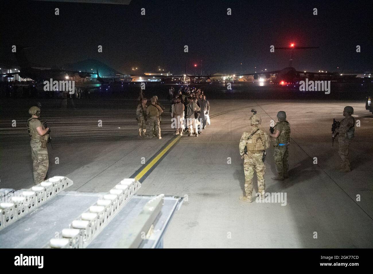 Des aviateurs américains, affectés au 816e Escadron de transport aérien expéditionnaire, guident les passagers à bord d'un C-17 Globemaster III de la Force aérienne des États-Unis à l'appui du refuge de l'opération alliés à l'aéroport international Hamid Karzaï (HKIA), en Afghanistan, le 22 août 2021. Banque D'Images