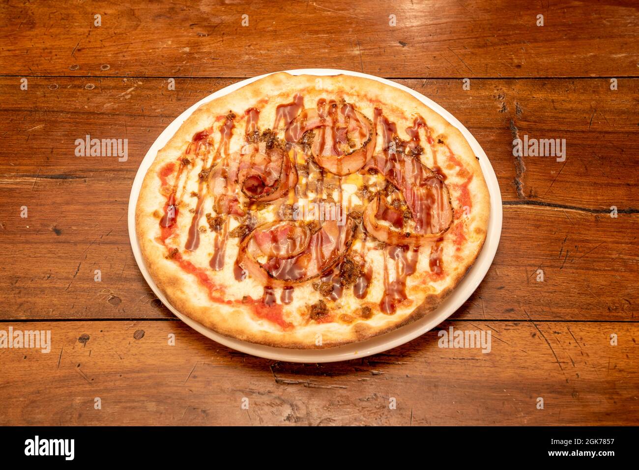 Pizza barbecue de taille individuelle avec tranches de bacon frite, sauce au fromage et à la mozzarella Banque D'Images