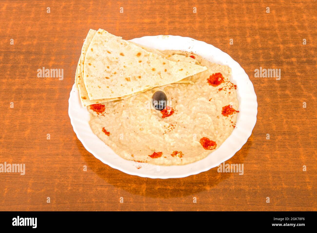 baba ganoush avec pain pita, olives noires et paprika sur une assiette blanche Banque D'Images