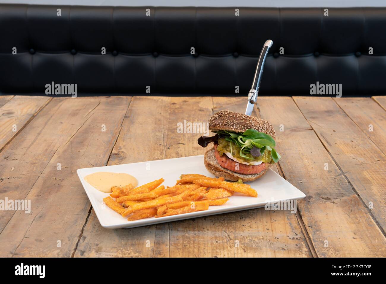 Fromage hamburger avec fromage de chèvre, oignons confits, pousses de laitue et patates douces Banque D'Images