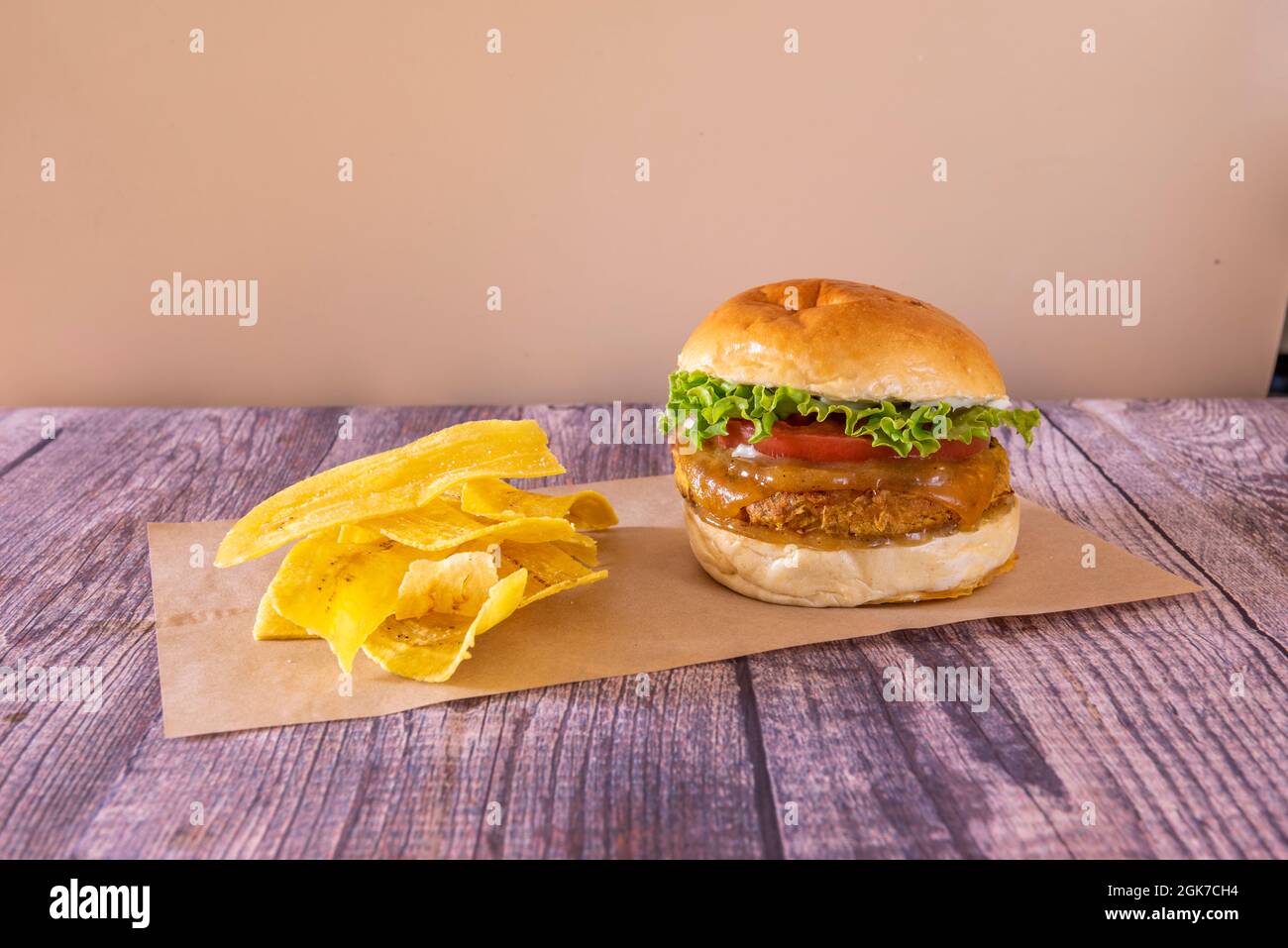 Excellent hamburger aux pois chiches végétaliens avec de la laitue, de la tomate et de la trompe l'oeil et une sauce sucrée avec des frites de banane Banque D'Images