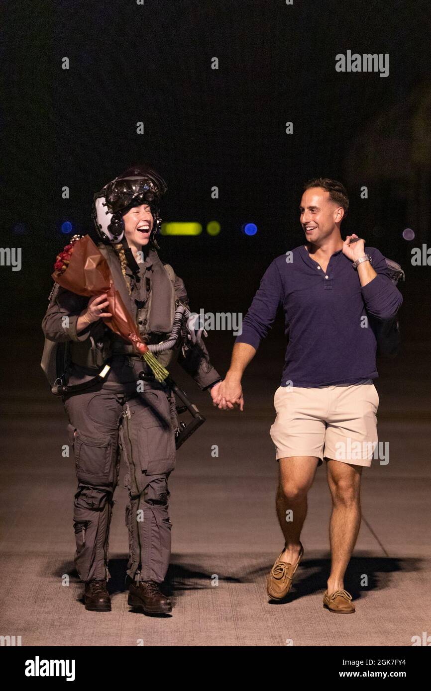 Le capitaine Anneliese Satz, un pilote F-35 de l'escadron d'attaque de chasseurs de Marines (VMFA) 121, marche avec le capitaine Anthony Pompei à son retour à la station aérienne du corps de Marines Iwakuni, au Japon, le 25 août 2021. SATZ et d'autres Marines affectés à l'escadron ont été déployés avec la 31e unité expéditionnaire maritime pour soutenir l'exercice Talisman Sabre. Cet exercice semestriel est la plus importante activité d'entraînement mixte bilatérale entre la Force de défense australienne et l'armée américaine. Banque D'Images