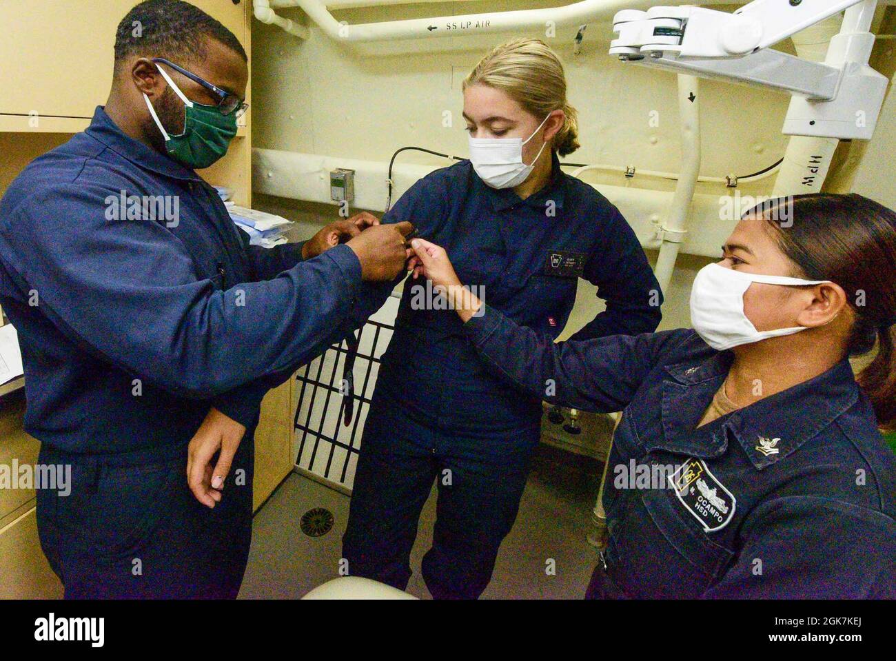 210827-N-MT581-1310 OCÉAN PACIFIQUE (AOÛT 27, 2021) Hospital Corpsman 2nd Faith Ocampo, à droite, de Honolulu, donne une formation sur l'application correcte d'un tourniquet au Seaman Harrison Rice, à gauche, de fort Worth, Texas, Et le Matelot-chef Alyza Nielsen, de Mora, Minn., dans le quai de transport amphibie USS John P. Murtha (LPD 26), à la station de dressage de combat arrière (BDS) pendant l'exercice Freedom Banner 2021, août 27. John P. Murtha participe à l'exercice Freedom Banner, un exercice annuel qui comprend une projection stratégique de la Force de prépositionnement maritime (FPM) et de l'exercice c associé Banque D'Images