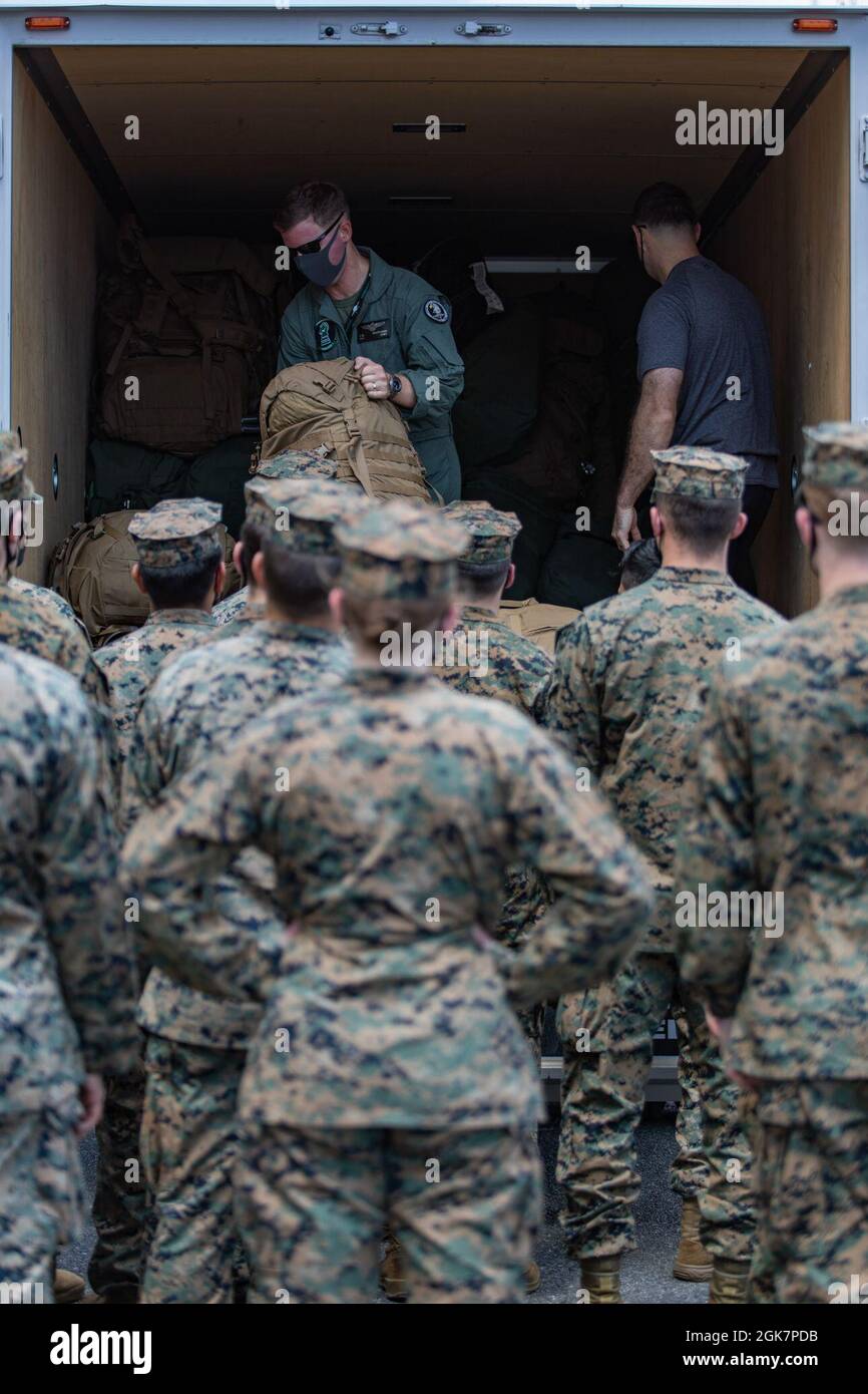 Le major Sean Walterman, du corps des Marines des États-Unis, à gauche, l'officier exécutif de l'escadron d'attaque des chasseurs de la Marine (VMFA) 121, et le capitaine Benjamin Hassel, un officier adjoint de maintenance des aéronefs affecté au VMFA-121, déchargent les colis et les sacs à leur retour à la station aérienne du corps des Marines Iwakuni, au Japon, le 28 août 2021. Les Marines affectés à l'escadron ont été déployées avec la 31e unité expéditionnaire maritime à l'appui de l'exercice Talisman Sabre. Cet exercice semestriel est la plus importante activité d'entraînement mixte bilatérale entre la Force de défense australienne et l'armée américaine. Banque D'Images