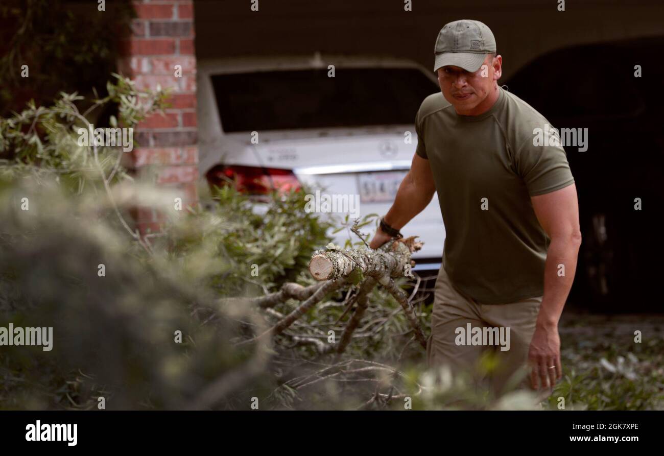 Un agent de la patrouille frontalière des États-Unis fait glisser des branches d'arbres délabrés vers une pile dans une résidence à la suite de l'ouragan Ida près de Baton Rouge, en Louisiane, le 31 août 2021. Banque D'Images