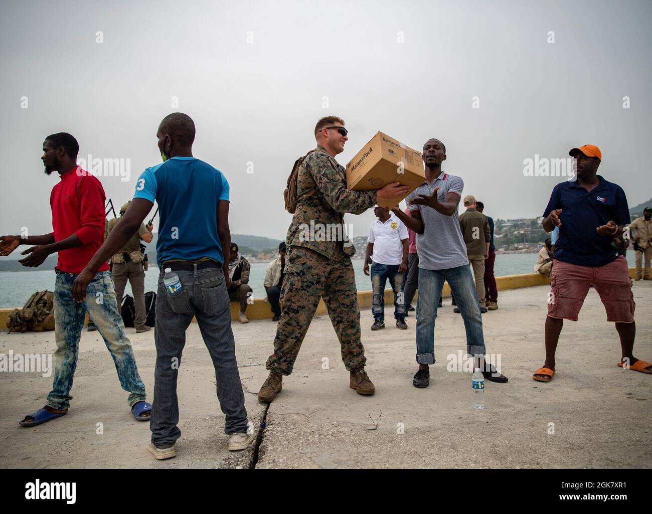 Une marine américaine avec la Force opérationnelle conjointe Haïti (foi-Haïti) et des bénévoles aident à décharger des boîtes pour redistribution à Port de Jeremie, Haïti, le 31 août 2021. Les Marines et les marins à bord de l'USS Arlington (LPD 24) ont travaillé à l'appui de la foi-Haïti pour une mission d'aide humanitaire et de secours en cas de catastrophe. Banque D'Images