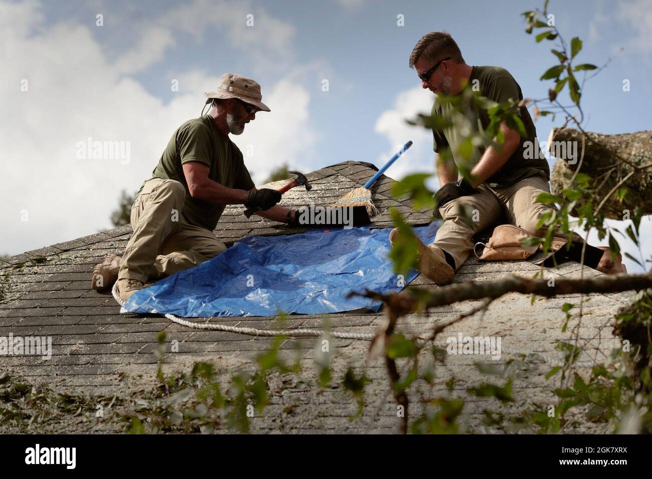 Les agents de la patrouille frontalière des États-Unis patchont temporairement un toit résidentiel perforé avec une bâche après l'ouragan Ida près de Baton Rouge, en Louisiane, le 31 août 2021. Banque D'Images