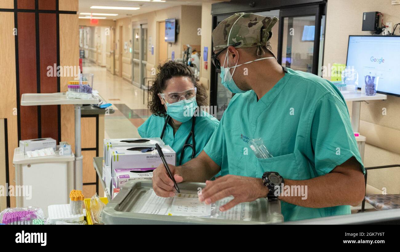 ALEXANDRIA, Louisiane -- (de gauche à droite) U.S. Air Force Capts. Holly Fletcher, gauche, Et Luis Dixon, à droite, les deux infirmières en traumatologie d'urgence affectées au 633e Escadron des opérations de soins de santé, base aérienne de Langley, en Virginie, discutent des processus tout en travaillant dans le cadre d'une équipe de soutien médical du DOD COVID-19 dans la salle d'urgence du Centre médical régional de rapides à Alexandria, en Louisiane, le 31 août 2021. Un MST est rapidement déployé dans un hotspot COVID-19 après que les demandes de la FEMA ou d'autres organismes fédéraux responsables ont été vérifiées pour les capacités et pour s'assurer qu'il s'agit de la solution appropriée pour la mission. U. Banque D'Images