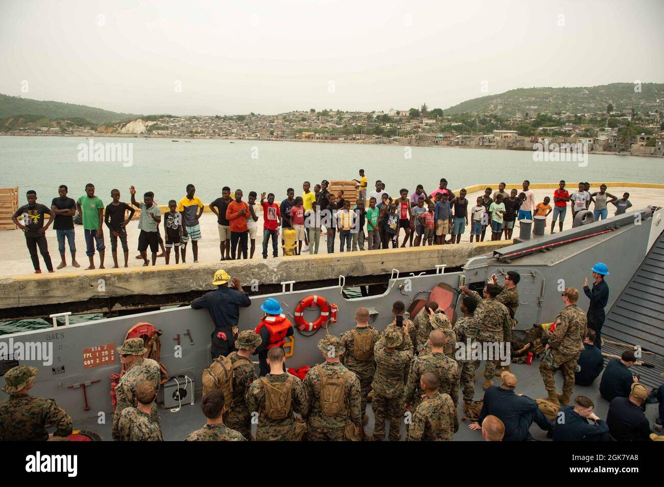 210831-N-MD802-1053 JÉRÉMIE, Haïti - (août 31, 2021) — des marins et des Marines, déployés avec le navire de transport amphibie de classe San Antonio USS Arlington (LPD 24), font la vague Au revoir aux citoyens haïtiens du port de Jérémie, en Haïti, à la suite d'une livraison de nourriture à l'appui d'une Agence américaine pour le développement international Banque D'Images