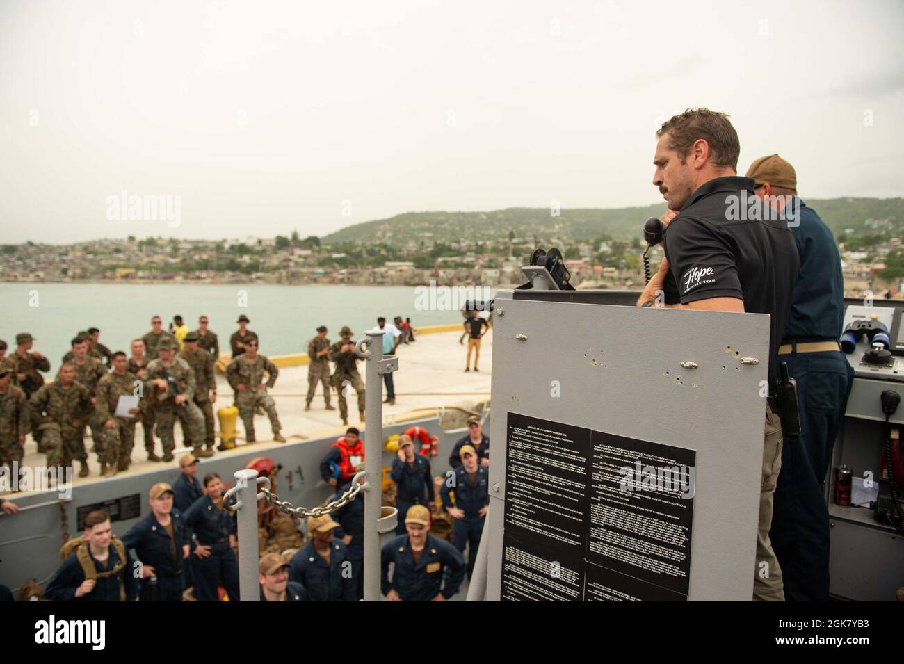 210831-N-MD802-1286 JÉRÉMIE, Haïti - (août 31, 2021) -- Austin Holmes, un représentant de Mission de l'espoir, parle aux marins et aux Marines, déployés avec le navire de transport amphibie de classe San Antonio USS Arlington (LPD 24), au port de Jérémie, en Haïti, après que l'équipage a livré de la nourriture pour soutenir une Agence américaine pour le développement international Banque D'Images