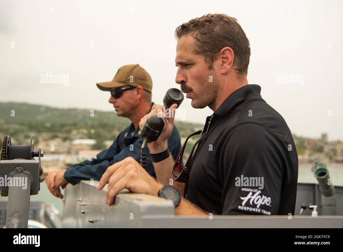 210831-N-MD802-1022 JÉRÉMIE, Haïti - (août 31, 2021) — Austin Holmes, un représentant de Mission of Hope, parle aux marins et aux Marines, déployés avec le quai de transport amphibie de classe San Antonio USS Arlington (LPD 24), au port de Jérémie, en Haïti, après la livraison de nourriture à l'appui d'une Agence américaine pour le développement international Banque D'Images