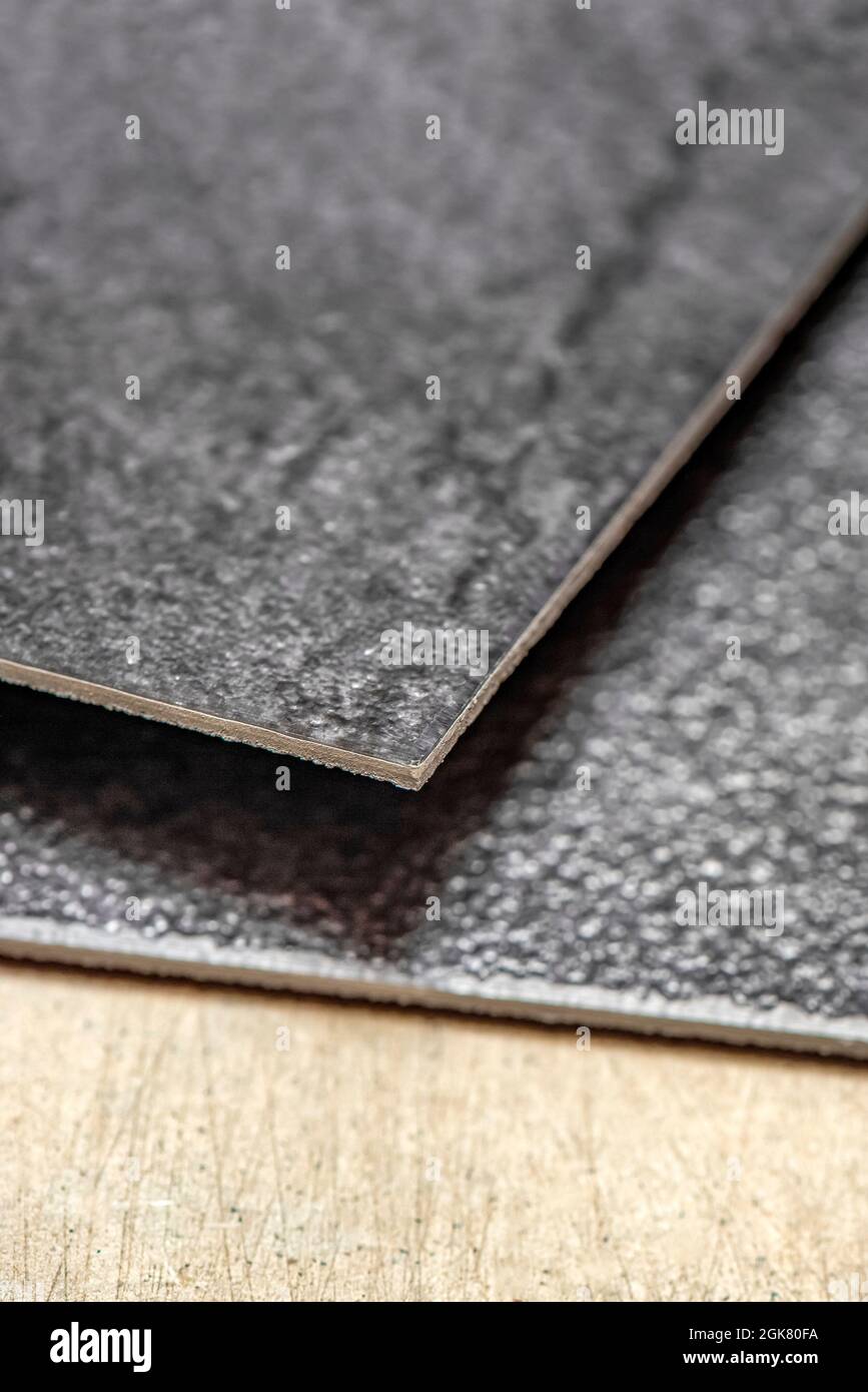 Plancher en PVC vinyle. La texture du plancher en vinyle est noire. Échantillons de revêtement en vinyle, carreaux en pvc noir sur sol en béton avant l'installation. Banque D'Images