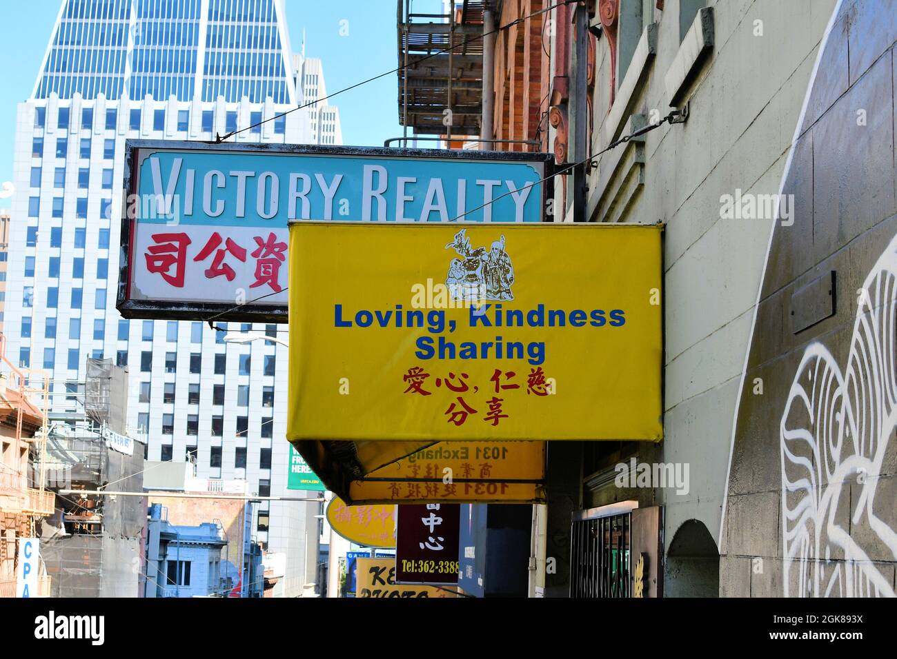 Un signe d'auvent jaune à Chinatown, San Francisco, Californie avec les mots aimer, bonté, et partage en anglais et chinois. Banque D'Images