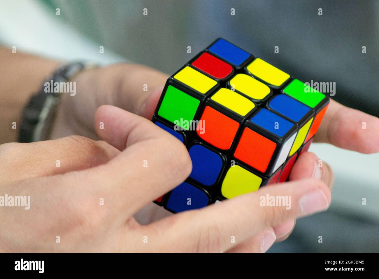 Gros plan des mains résolvant un Rubik's Cube. Casse-tête de couleur