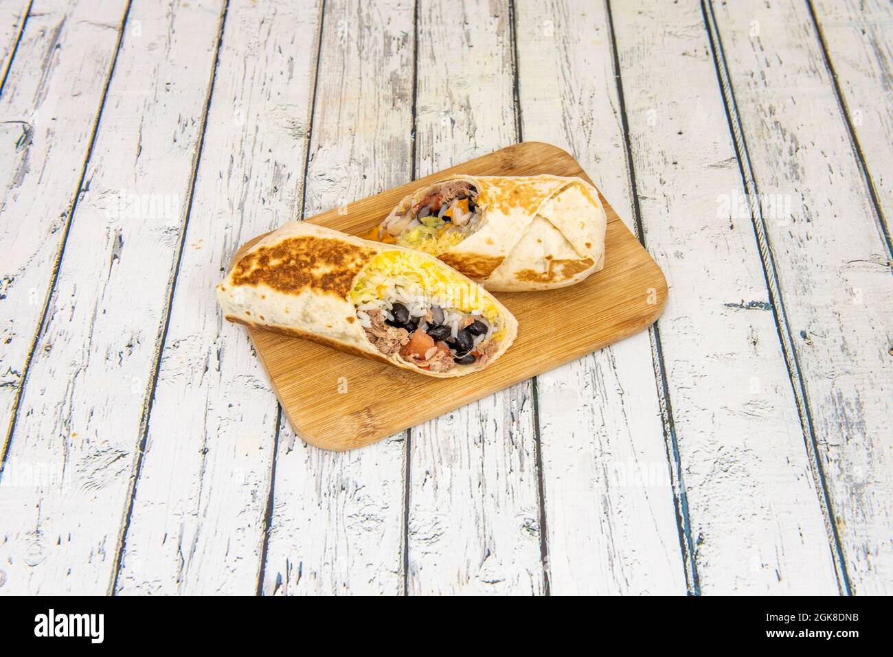 Tortilla burrito de blé grillé mexicain avec porc tiré, haricots noirs, riz et fromage cheddar Banque D'Images