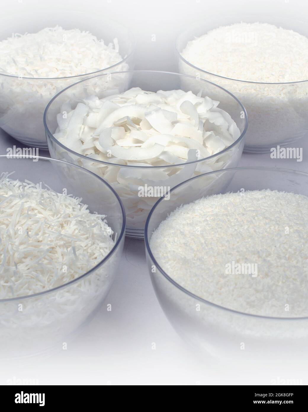 Assortiment de noix de coco déshydratées dans un bol rond. Isolé sur blanc. Banque D'Images