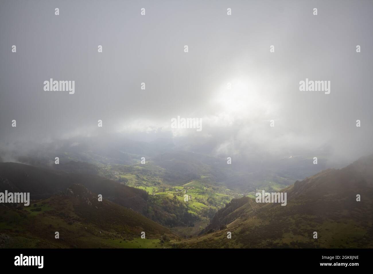 Depuis le dessus des collines verdoyantes pittoresques et de la vallée sous d'épais nuages gris avec la lumière du soleil Banque D'Images