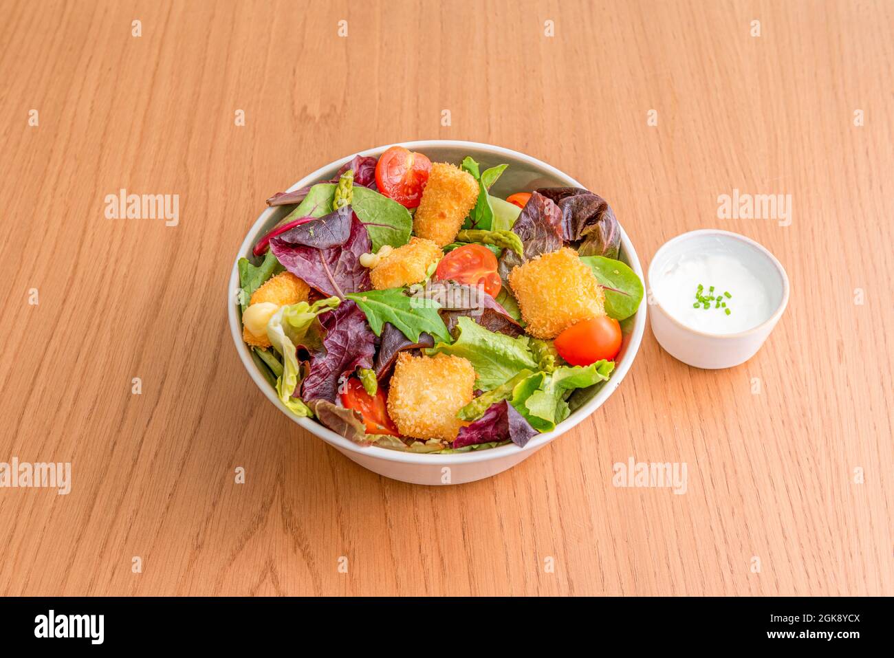 salade de pousses de laitue mélangée, nuggets de poulet, asperges vertes, tomates cerises et sauce mayonnaise Banque D'Images