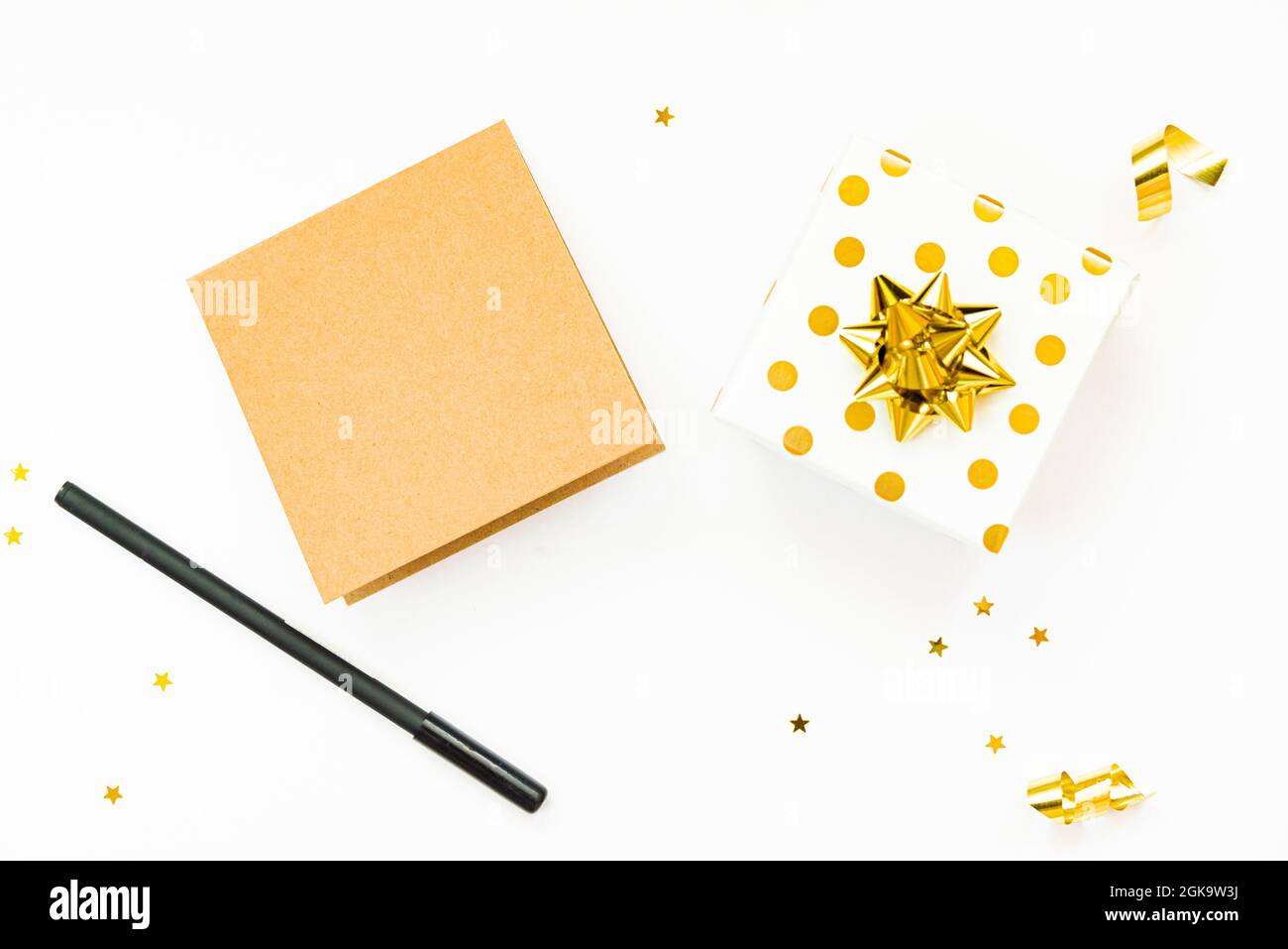 Vue de dessus des boîtes-cadeaux en pointillés dorés et de la carte vide sur fond blanc. Espace de copie, maquette. Banque D'Images
