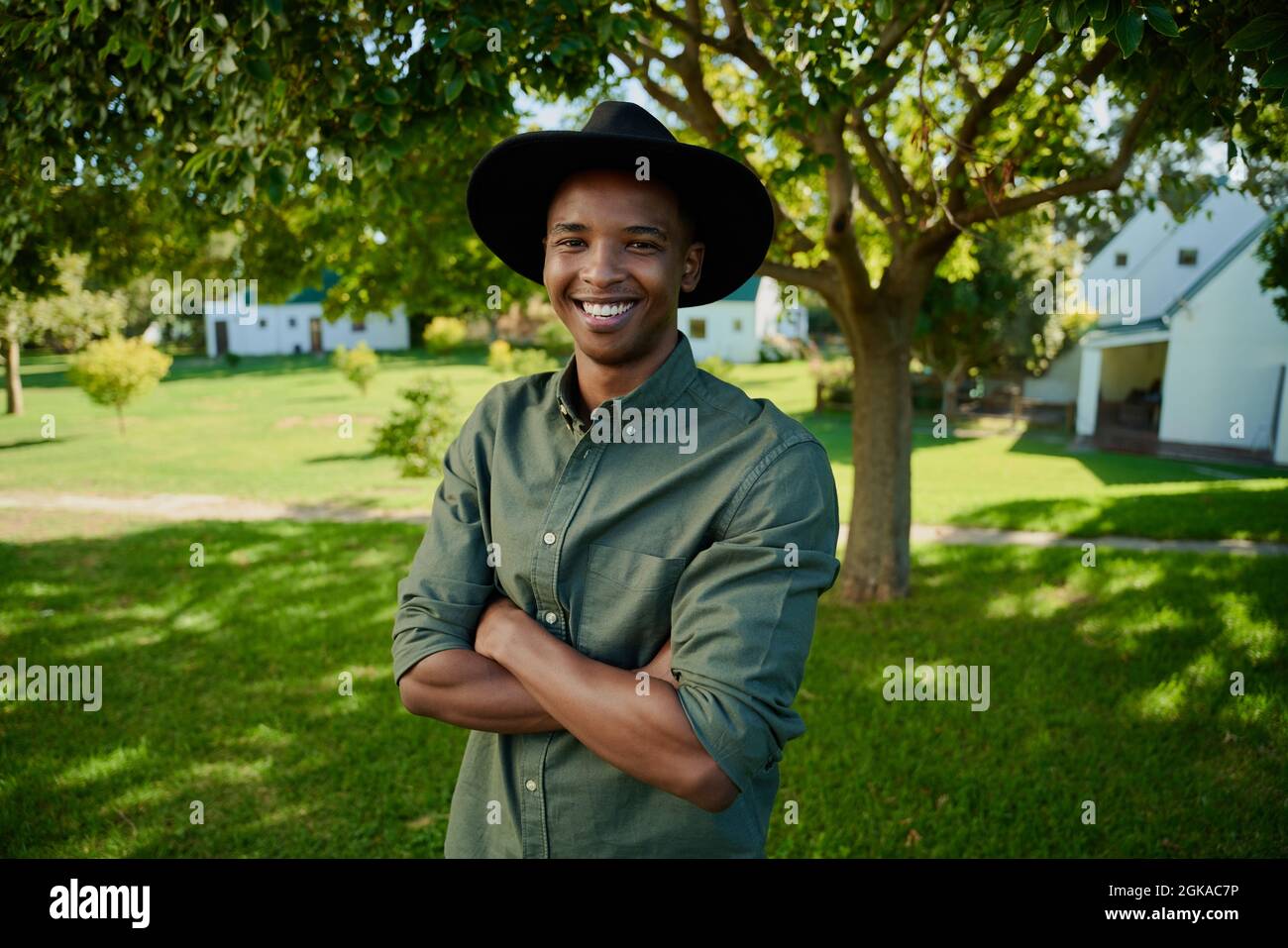 Fermier masculin de race mixte debout à l'extérieur avec les bras croisés Banque D'Images