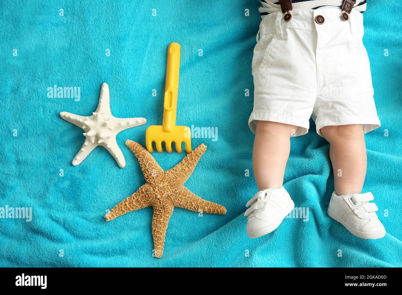 Bebe Mignon Avec Des Etoiles De Mer Et Un Rateau De Jouet Allonge Sur Un Couvre Lit Bleu Concept De Vacances Photo Stock Alamy