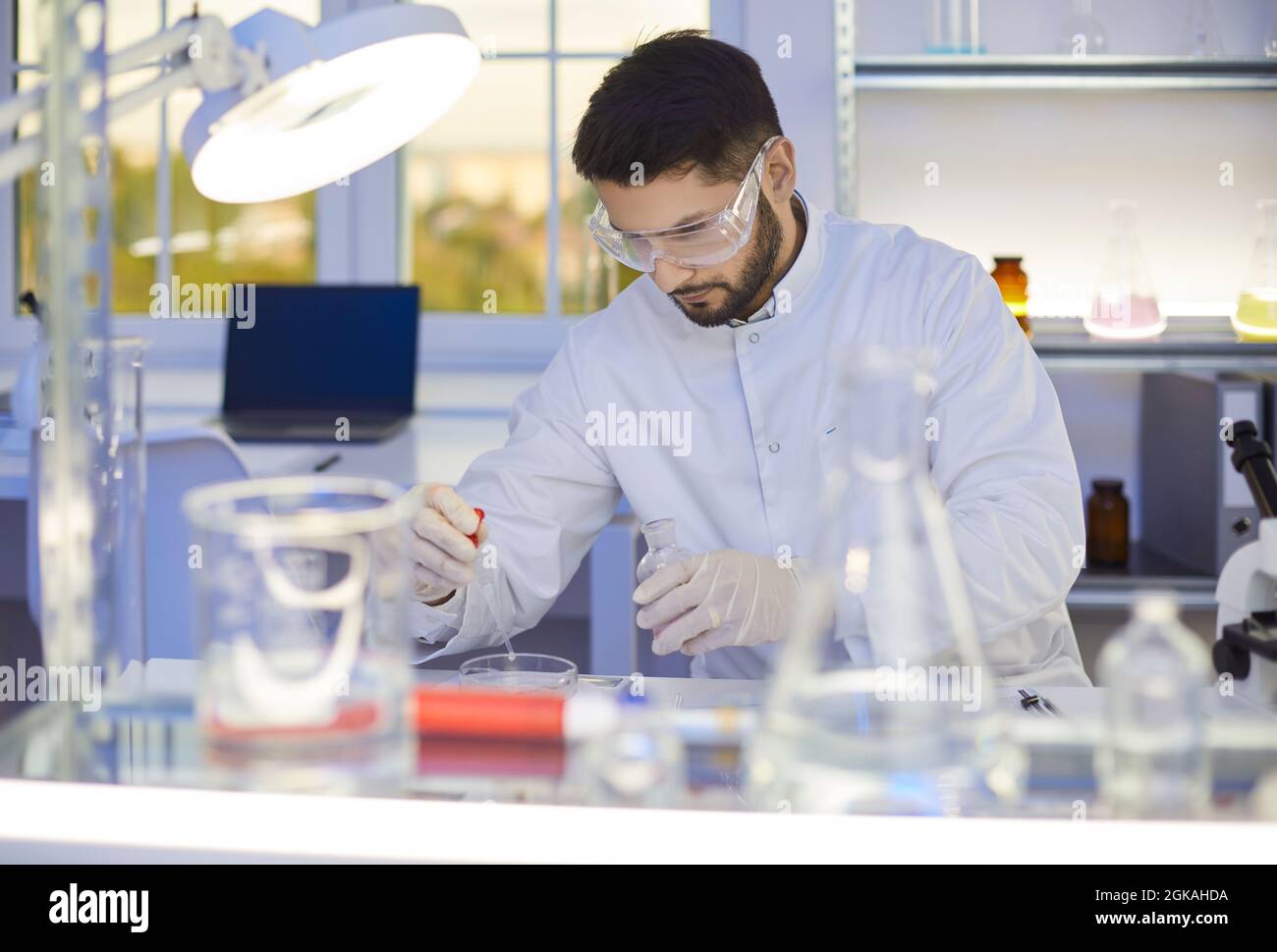 Chercheur scientifique masculin travaillant avec des produits chimiques en laboratoire scientifique Banque D'Images