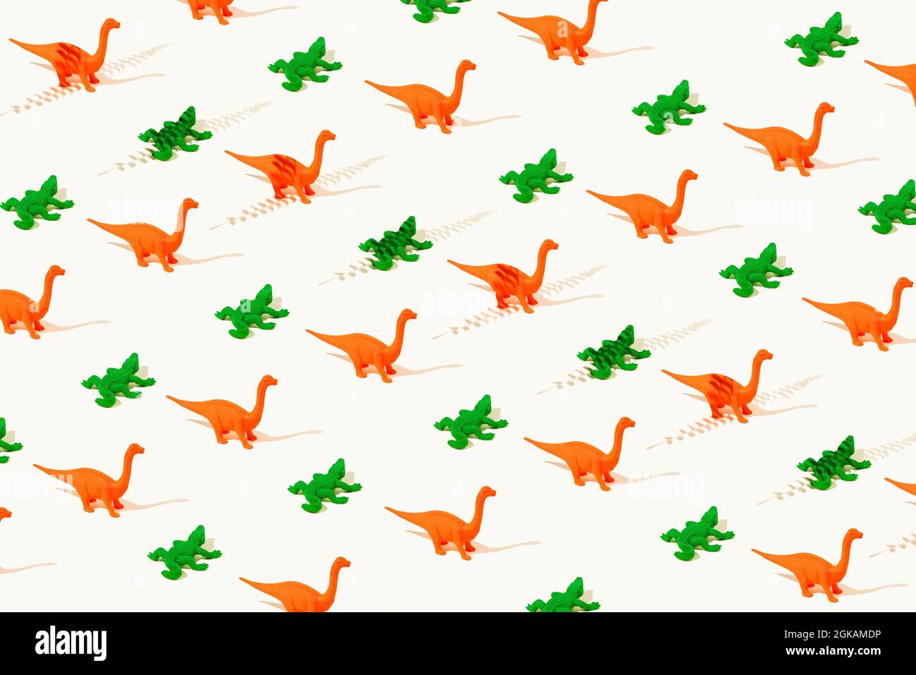 Papier peint créatif motif sans couture de dinosaures en caoutchouc orange et de crocodiles verts sur un fond jaune clair. Présentation isométrique. Concept abstrait. Banque D'Images