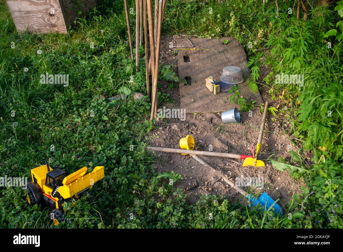 Jardin de jeu pour enfants avec camion et jouets vert herbe jaune terre Banque D'Images