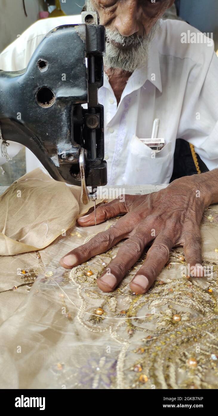 mains des vieux hommes travaillant dans la machine à coudre. machine à broder chemise pour femmes Banque D'Images