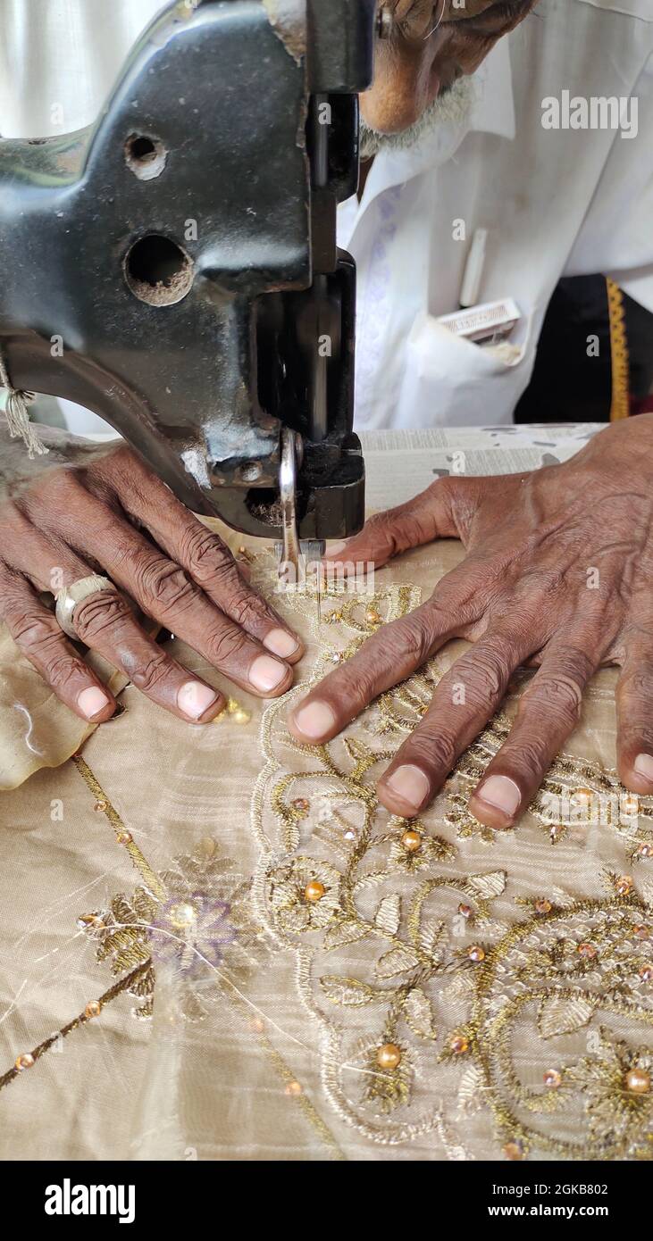 mains des vieux hommes travaillant dans la machine à coudre. machine à broder chemise pour femmes Banque D'Images