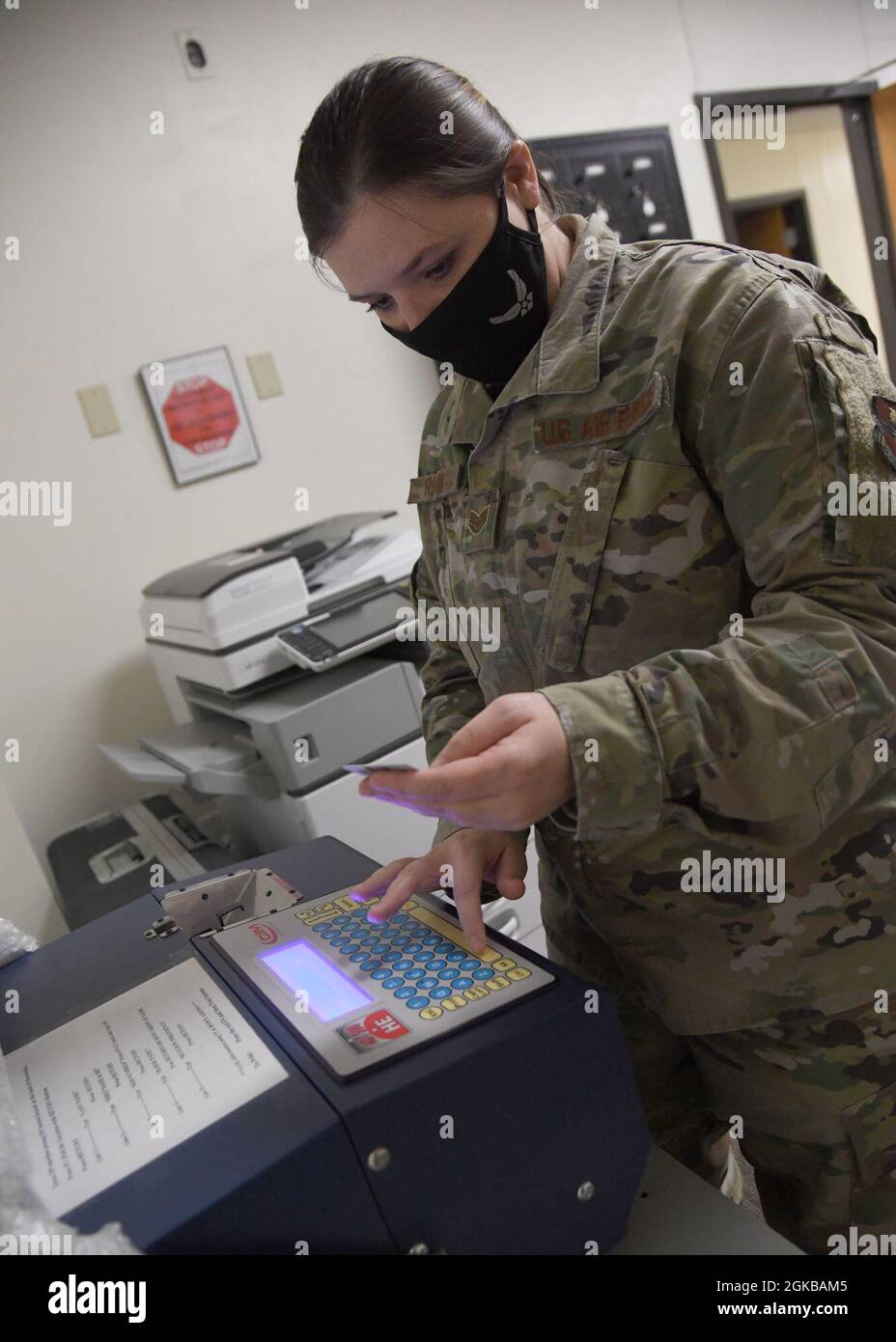 Sergent d'état-major de la Force aérienne des États-Unis Krista Reeves, 81e Escadron de soutien de la Force préparation du personnel d’installation NCO responsable, entre ses renseignements dans une machine à étiquettes de chien à l’intérieur du Centre logistique de Taylor, à la base aérienne de Keesler, Mississippi, le 2 mars 2021. Après que la Force aérienne a modifié sa politique pour permettre aux Indiens d'Amérique d'identifier leur tribu ou leur nation sur leurs étiquettes d'identification, Keesler a été le premier à émettre une paire. Banque D'Images