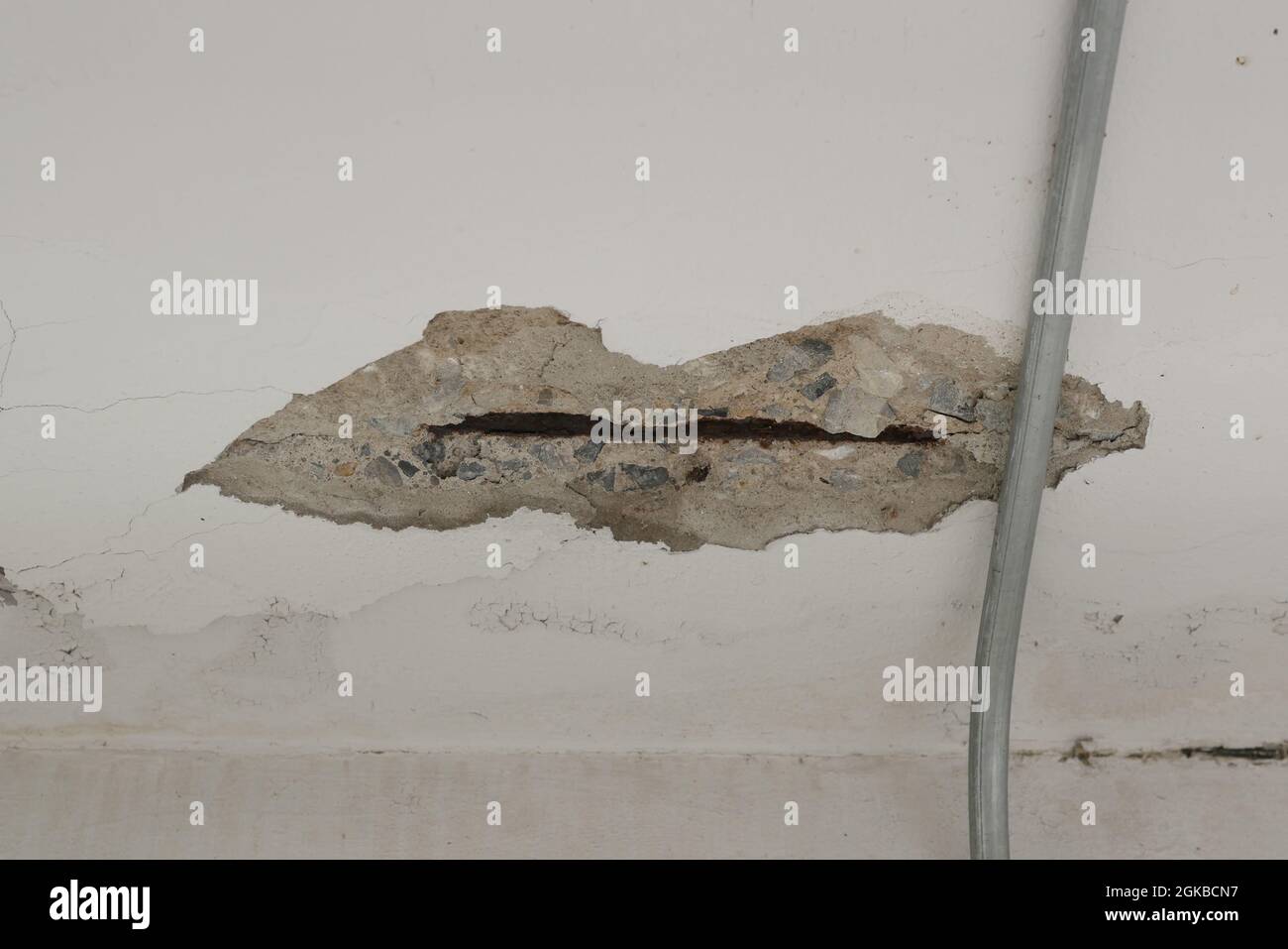 Gros plan de petites fissures sur le vieux mur blanc Banque D'Images