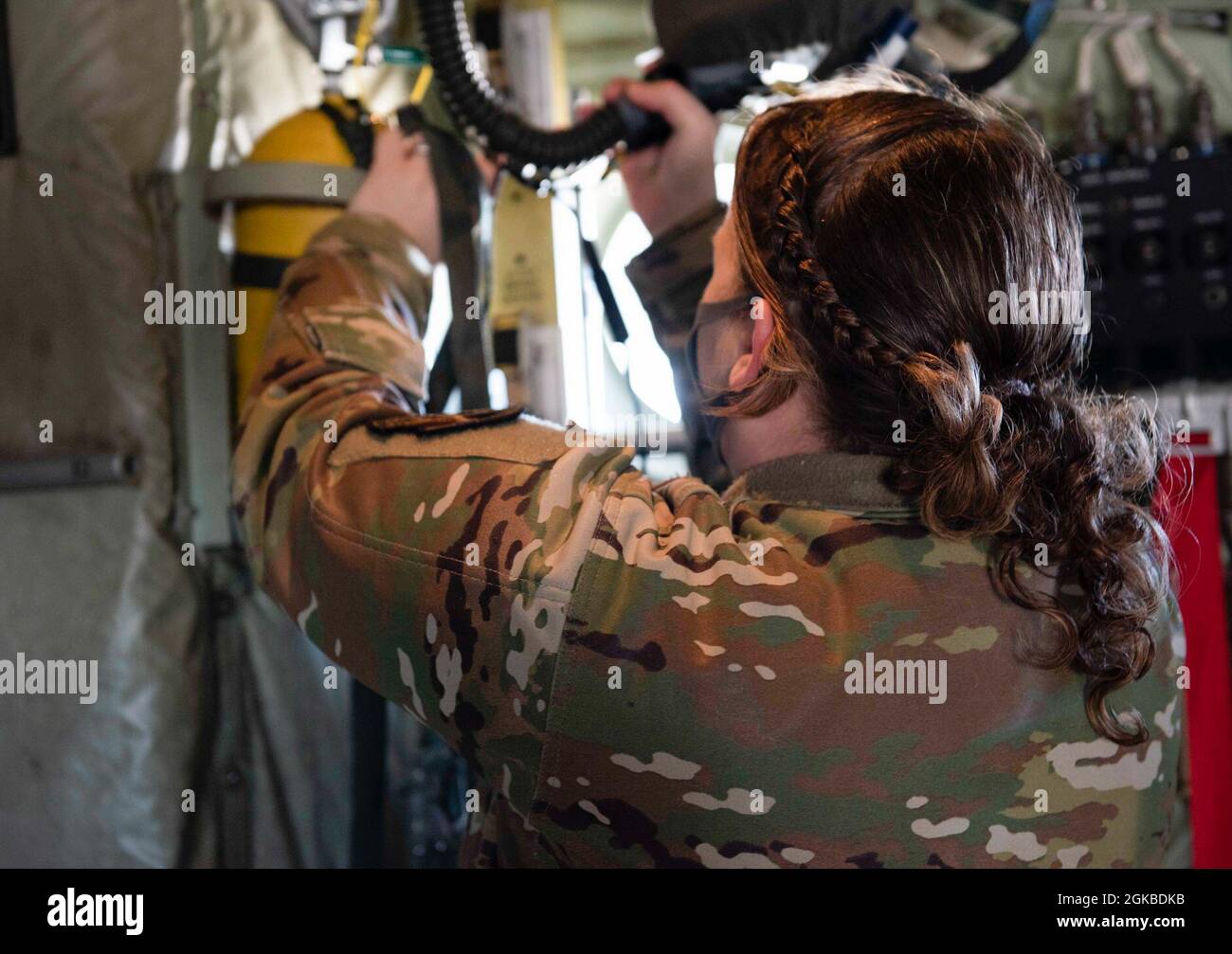 Sergent d'état-major Teara Sapp Becker, conseillère en ressources du 36e Escadron de transport aérien NCO en charge et instructeur de charge, inspecte l'équipement à l'intérieur d'un C-130J Super Hercules lors d'une inspection avant vol, le 3 mars 2021, sur la base aérienne de Yokota, au Japon. Une nouvelle mise à jour sur l'instruction de la Force aérienne a été publiée le 10 février 2021, permettant aux femmes de la Force aérienne de porter leurs cheveux dans une ou deux braïdes, ou une queue de cheval qui s'arrête avant l'entrejambe sous les aisselles. Banque D'Images