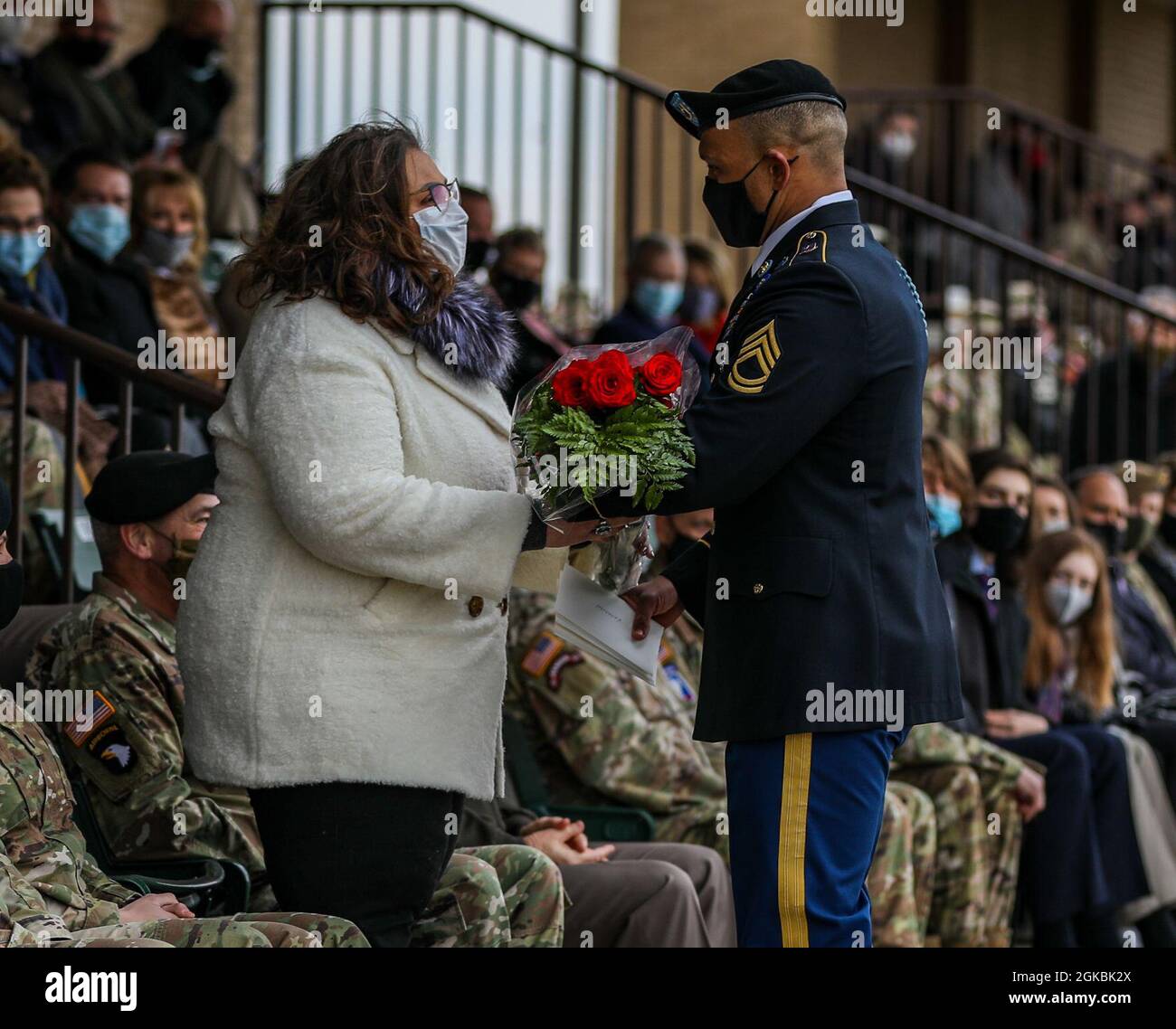 Kim Winski, épouse du général commandant sortant de la 101e Division aéroportée (assaut aérien), général de division Brian Winski, reçoit un bouquet de fleurs rouges lors de la cérémonie de changement de commandement de division le 5 mars 2021, au champ de parade de division, fort Campbell, Ky. Les fleurs rouges sont données à la femme de l’ancien général comme un cadeau de remerciement pour son dévouement et son engagement envers la division. Banque D'Images