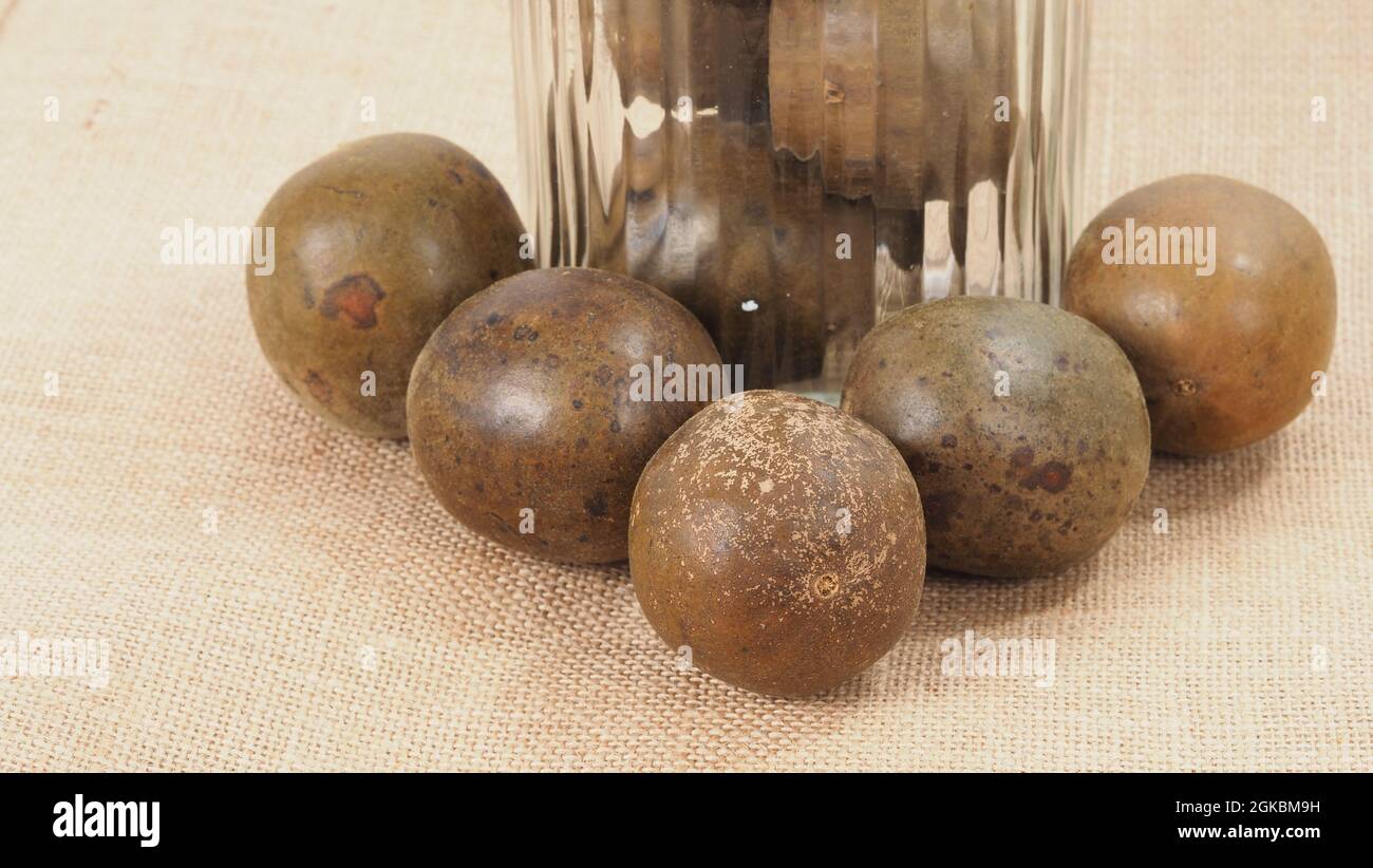 Monk fruit ou Luo Han Guo. Fruits secs pour une boisson saine d'édulcorant. Remède naturel à base de plantes et fond de bouteille en verre. Boisson aux fruits Monk pour qui conce Banque D'Images