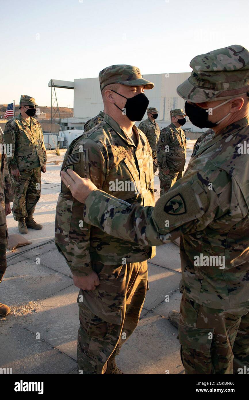 Le Maj Jeremy Taylor, aumônier du 734e groupe de soutien régional de la Garde nationale de l'Iowa, reçoit son insigne militaire à manches d'épaule dans des conditions hostiles lors d'une cérémonie sur le toit à la base aérienne d'Al Asad, en Irak, le 5 mars 2021. Le fait de donner l'insigne de la manche à l'épaule, plus connu sous le nom de patch de combat, est un rite de passage pour les déployeurs de première fois. Banque D'Images