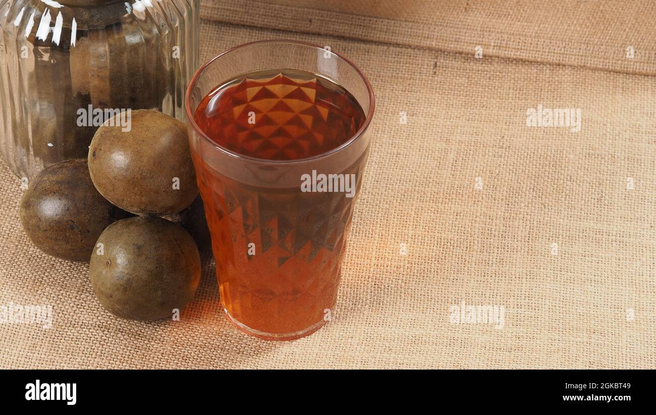 Monk fruit ou Luo Han Guo. Fruits secs pour une boisson saine d'édulcorant. Remède naturel à base de plantes et fond de bouteille en verre. Boisson aux fruits Monk pour qui conce Banque D'Images