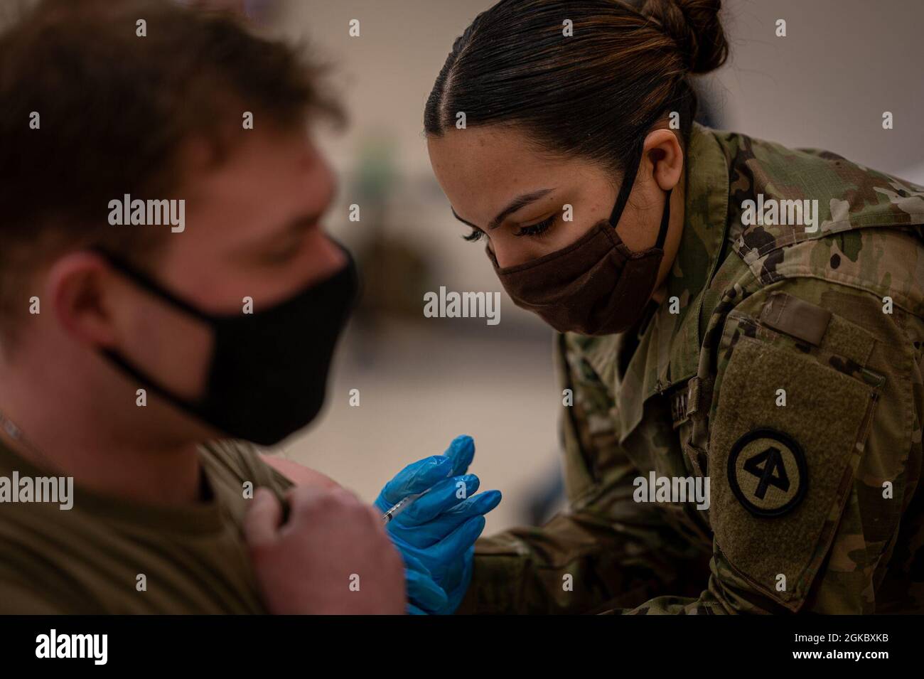 Sergent de l'armée américaine Alexa Caramb, medic de Charlie Company, 250e Bataillon de soutien de brigade, donne la vaccination COVID-19 à un soldat de la base interarmées McGuire-Dix-Lakehurst, N.J., le 6 mars 2021. Le centre de vaccination a été dirigé par le 108e Groupe médical, la Garde nationale aérienne du New Jersey. Banque D'Images