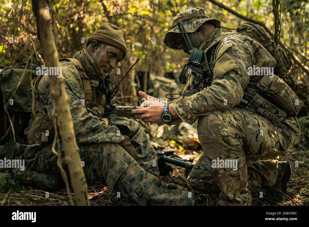 Caporal du corps des Marines des États-Unis Tanner Graham (à gauche), un chef d'équipe adjoint avec 3d reconnaissance Battalion, 3d Marine Division et U.S. Air Force Tech. Sgt. Scott Survian, un aviateur de reconnaissance spécial du 320e Escadron de tactiques spéciales, discute de la tenabilité des pistes à la suite d'un relevé sur le terrain d'aviation d'IE Shima, Okinawa, Japon, le 10 mars 2021 dans le cadre de Castaway 21.1. Cet exercice a démontré la capacité du corps des Marines à s’intégrer à la force conjointe pour s’emparer et défendre des terrains maritimes clés, fournir un soutien de faible envergure et exécuter des feux de précision à longue portée à l’appui des opérations navales fr Banque D'Images