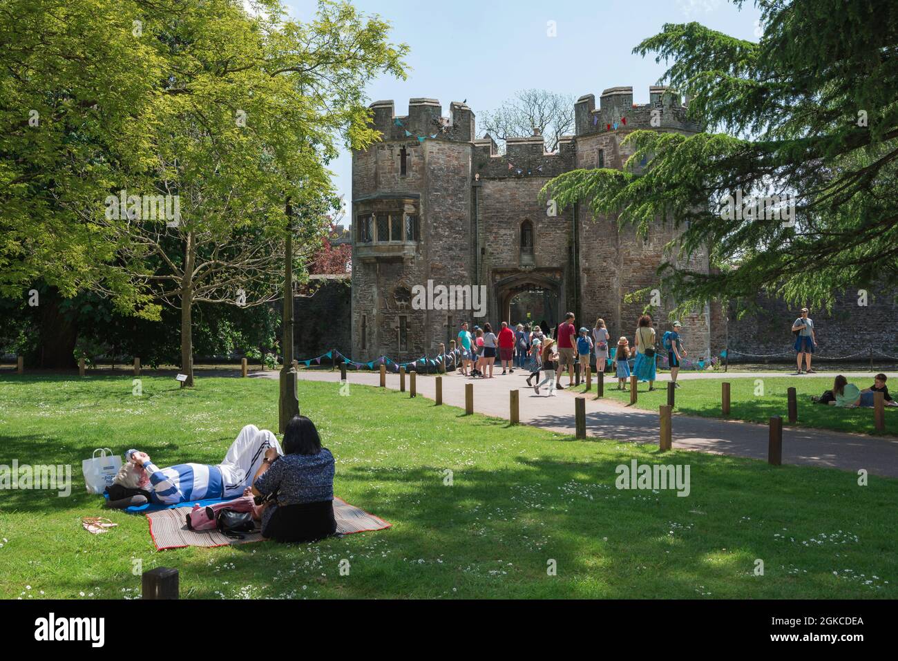 L'été de l'Angleterre, vue en été des personnes se détendant à l'intérieur des jardins du Palais de Bishop dans la ville historique de la cathédrale de Wells, Somerset, Angleterre, Royaume-Uni Banque D'Images