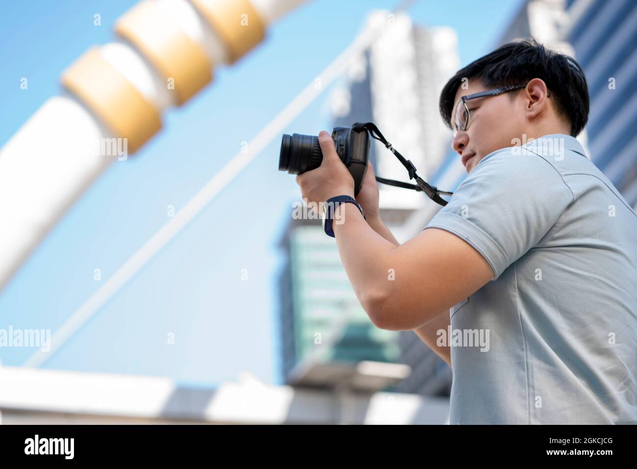 Happy Man voyageur avec appareil photo prendre des photos au centre du bâtiment arrière-plan. Banque D'Images
