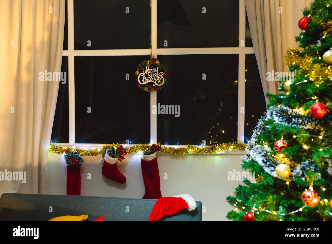 Composition de l'affiche de joyeux noël dans la fenêtre, avec des bas de noël et un sapin de noël Banque D'Images Composition de l'affiche de joyeux noël dans la fenêtre, avec des bas de noël et un sapin de noël Banque D'Images